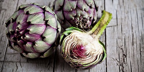 fresh artichokes on rustic wooden background