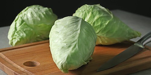 Fresh pointed cabbage on wooden board