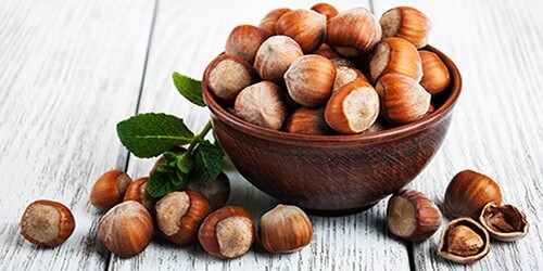 Bowl with hazelnuts on a old wooden table