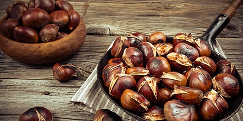 chestnuts in a pan on a wooden background