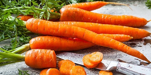 Fresh organic carrots on old wooden board