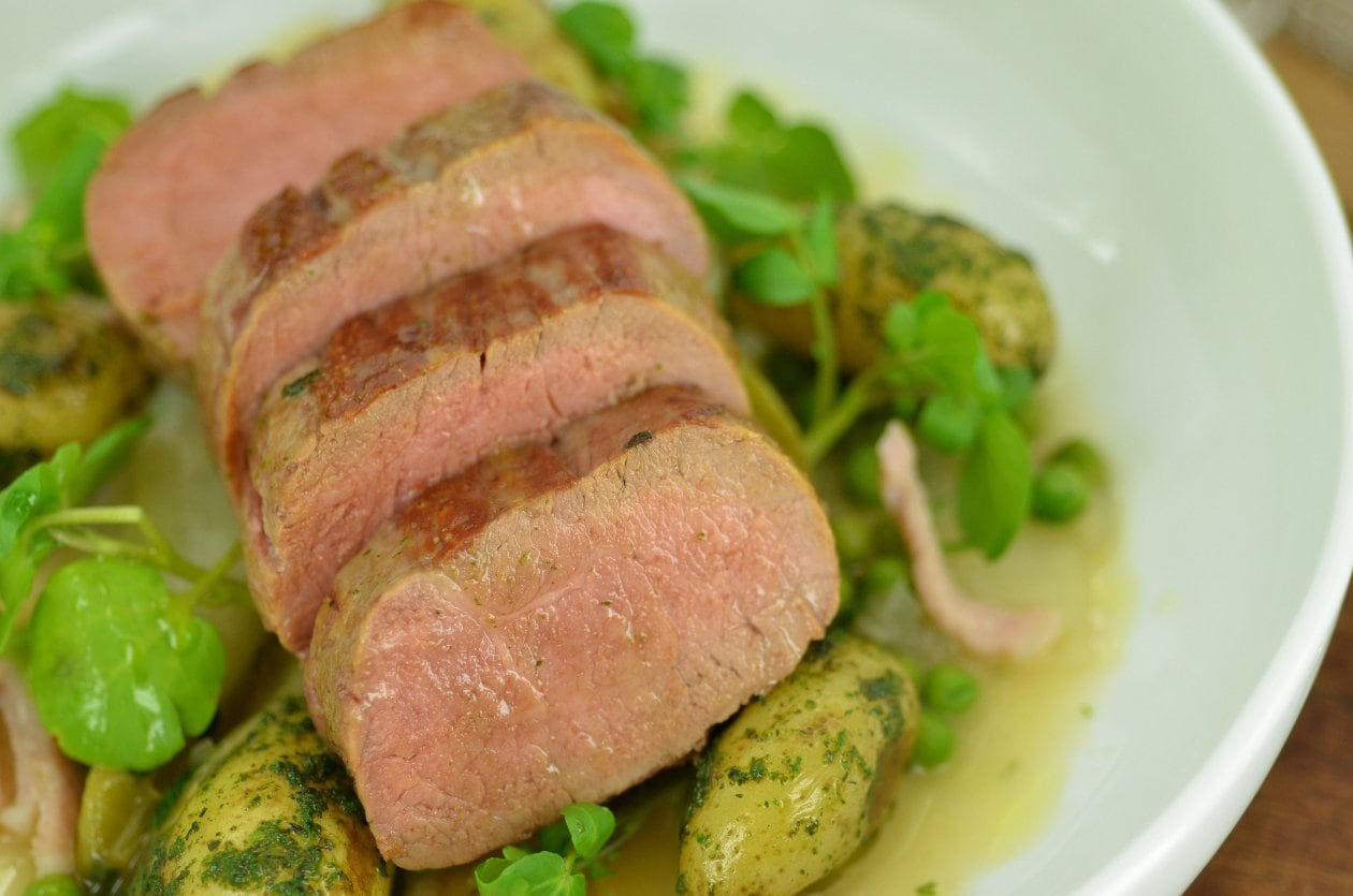 Roast lamb loin with peas, chicory & bacon